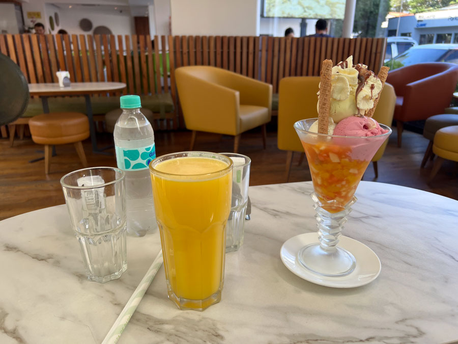 Juice and ice cream sundae on table